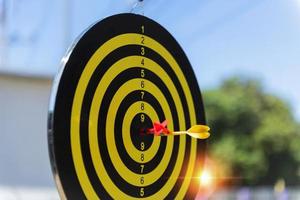 Two dart hit it's target on a red background, concept for success,darts motion blur. photo