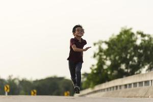 un niño pequeño corre a lo largo del puente. foto