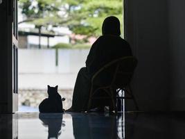 silueta de una mujer y un gato esperando en la puerta principal foto