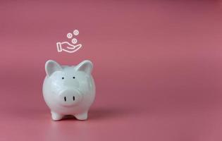 white piggy bank on a pink background. Savings and investment concepts. photo