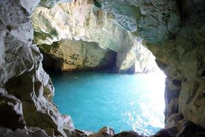 Grottoes in the chalk cliffs on the shores of the Mediterranean Sea. photo