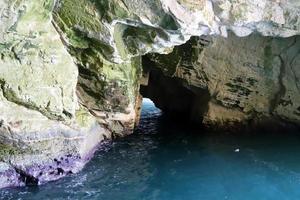 Grottoes in the chalk cliffs on the shores of the Mediterranean Sea. photo