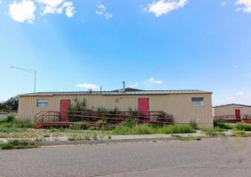 Abandoned Modular Building With Overgrown Weeds photo