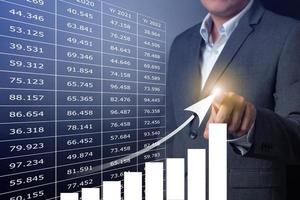 Double exposure of close up businessman touching on growth up chart with balck and gray background photo