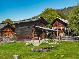 Old Mill with millwheel and other old, alpine buildings photo