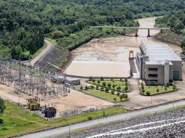 la central hidroeléctrica cerca de la gran presa de tierra en el valle. foto