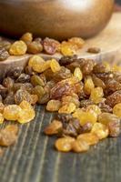 Dried yellow golden raisins on a board photo