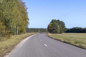 Paved road in the autumn season in sunny weather photo