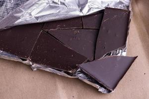 A broken chocolate bar in a paper and foil package photo