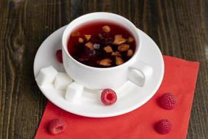 Red raspberry tea with pieces of fruit and berries photo