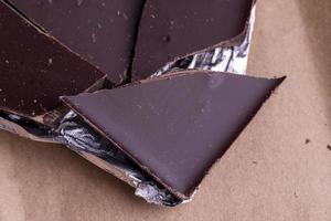 A broken chocolate bar in a paper and foil package photo
