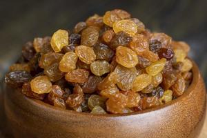 Dried yellow golden raisins on a board photo