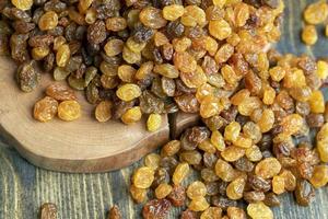 Dried yellow golden raisins on a board photo