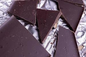 A broken chocolate bar in a paper and foil package photo