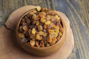 Dried yellow golden raisins on a board photo