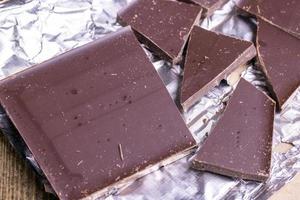A broken chocolate bar in a paper and foil package photo