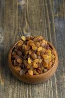 Dried yellow golden raisins on a board photo