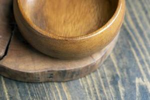 cuenco de madera sobre mesa de madera, cuenco redondo vacío para comestibles y comida foto