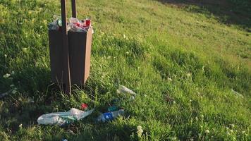 överfyllda skräp bin utomhus i solnedgång ljus. miljö- förorening begrepp. plast avfall. video