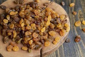 Dried yellow golden raisins on a board photo