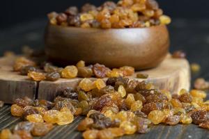 Dried yellow golden raisins on a board photo