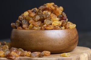 Dried yellow golden raisins on a board photo