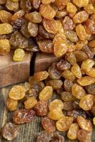 Dried yellow golden raisins on a board photo