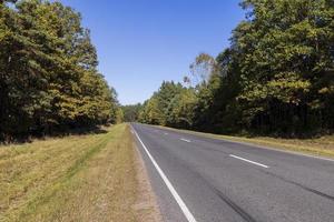 Paved road in the autumn season in sunny weather photo