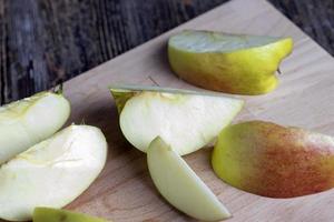 manzana madura en rodajas en una tabla de cortar foto