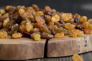 Dried yellow golden raisins on a board photo