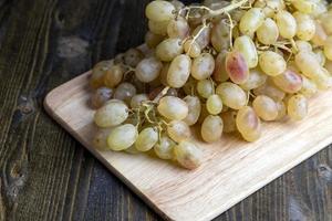 Green grapes unwashed lying on the board photo