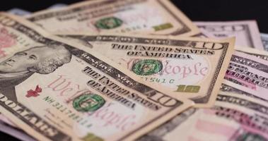 folding American cash ten-dollar bills on black paper photo