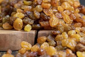 Dried yellow golden raisins on a board photo