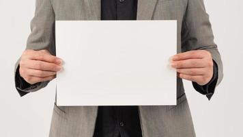 Man is wearing a gray suit and holding the paper board on white background. photo