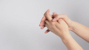 Male model is interlace fingers and continue rubbing on white background. photo