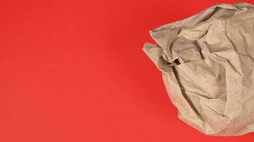 Crumpled brown paper.It is mauled on red background. photo