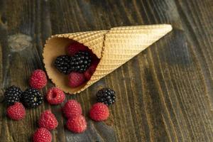 frambuesas rojas maduras en un cono de galleta crujiente foto