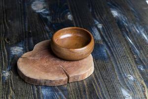 Wooden bowl on wooden table, empty round bowl for groceries and food photo