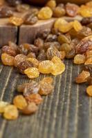 Dried yellow golden raisins on a board photo