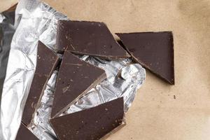 A broken chocolate bar in a paper and foil package photo