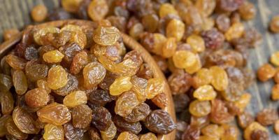 Dried yellow golden raisins on a board photo