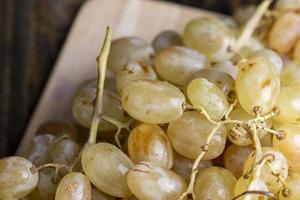 Green grapes unwashed lying on the board photo