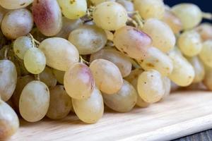 Green grapes unwashed lying on the board photo