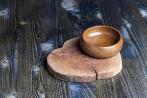 Wooden bowl on wooden table, empty round bowl for groceries and food photo