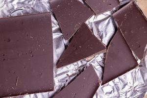 A broken chocolate bar in a paper and foil package photo