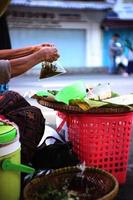 An old Indonesian woman is preparing Pecel dishes  for customers. Natural food. photo