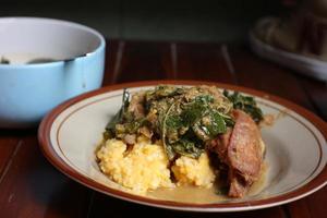 Yellow rice with cassava leaves and fried chicken photo