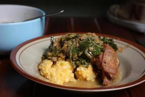 Yellow rice with cassava leaves and fried chicken photo
