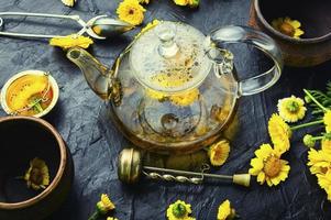 tetera con té de flores frescas, medicina herbaria foto