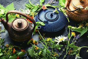 Teapot with fresh medicinal herbs photo